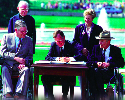 A photograph of President George H. Bush signing the ADA act in to law on July 20th 1990.